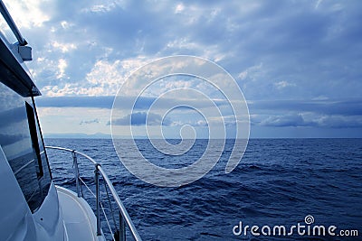 Boat sailing in cloudy stormy day blue ocean Stock Photo