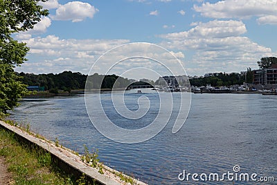 The boat sails along the river, on one side of which is a Marina, on the other side of the beach and vacationers Stock Photo