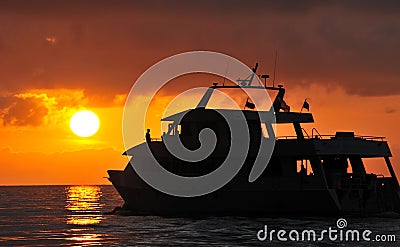 Boat silhouetted at sunset Stock Photo