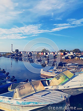 Boat station at the dawn of a summer sunny day with lots of boats and a blue sky reflecting in the water Editorial Stock Photo