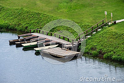 Boat station on the river and a green meadow, summer day, boats on the shore Stock Photo