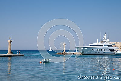 Boat and Statue Deer and hound and columns in Mandraki harbor. Editorial Stock Photo