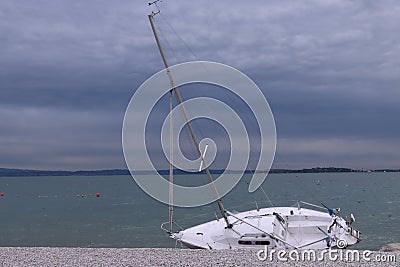 Boat with tree beached adrift due to natural unforeseen events Stock Photo