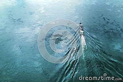 a boat or a tugboat is floating on the water of the river view from above. green blue water beautiful texture copy space Stock Photo