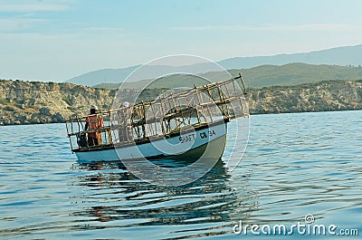 A boat in the water behind cliffs Editorial Stock Photo