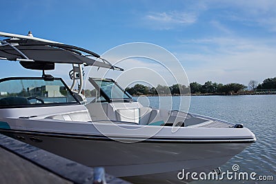 boat for water sports stranded at the pier during the midday with blue sky and a lake in the background Stock Photo