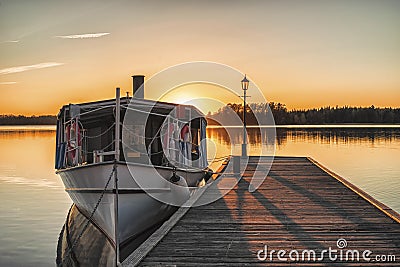 Boat at the wooden pier durin sunset Stock Photo