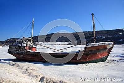 Boat wreck on frozen river Stock Photo