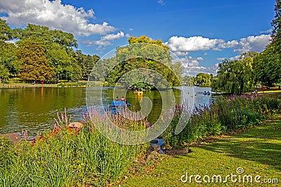 Boaters on lake in park, Birmingham, England Stock Photo