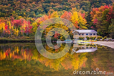 Boathouse and fall colors reflecting in Echo Lake, in Franconia Stock Photo