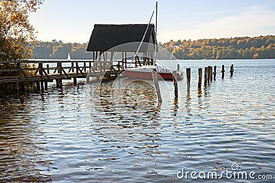 boathouse with jetty and sailing boat in the lake on a sunny autumn day, copy space Stock Photo