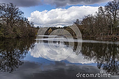 Boathouse and lake at Dudmaston with reflected clouds Stock Photo