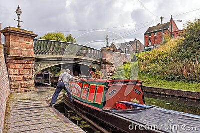 Boatman manoeuvring a Narrowboat, Dudley, West Midlands. Editorial Stock Photo