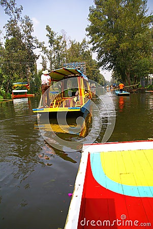 Boatman poling brightly colored boat Editorial Stock Photo