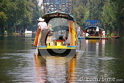 Boatman poling brightly colored boat Editorial Stock Photo