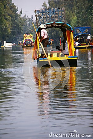 Boatman poling brightly colored boat Editorial Stock Photo