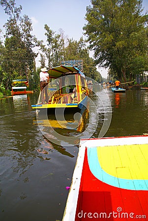 Boatman poling brightly colored boat Editorial Stock Photo