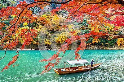 Boatman punting the boat at river. Arashiyama in autumn season along the river in Kyoto, Japan Stock Photo