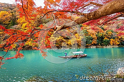 Boatman punting the boat at river. Arashiyama in autumn season along the river in Kyoto, Japan Editorial Stock Photo