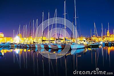 Boats in Alghero seaport on a clear night Stock Photo