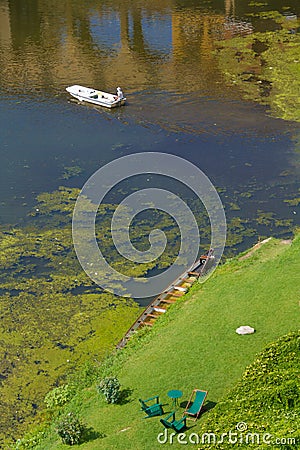 Boats in Arno Rive, Florencer and resting chairs at its bank Stock Photo