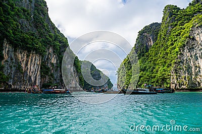 Boats on the blue water of the ocean surrounded by cliffs Stock Photo
