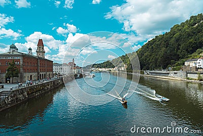 Boats cruising over the Danube river against the city and forest of Passau in Germany Editorial Stock Photo