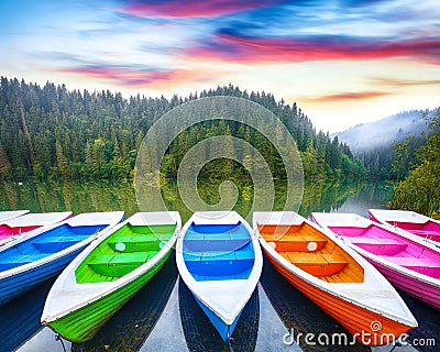 Boats on majestic mountain lake Lacul Rosu or Red Lake or Killer Lake Stock Photo