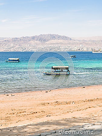 Boats near beach of Aqaba and view of Eilat city Editorial Stock Photo