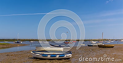 Boats on the shore and moored in Brancaster Bay near Burnham, Norfolk, UK Stock Photo