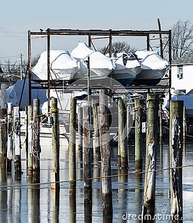 Boats shrink wrapped for the winter stored over water Stock Photo