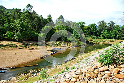 Boats wait outside the entrance of Kong Lor Cave Stock Photo