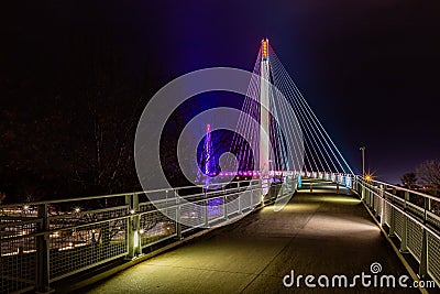 On Bob Kerrey pedestrian bridge Omaha Nebraska at night with lights of various colors on the suspension towers and cables. Stock Photo
