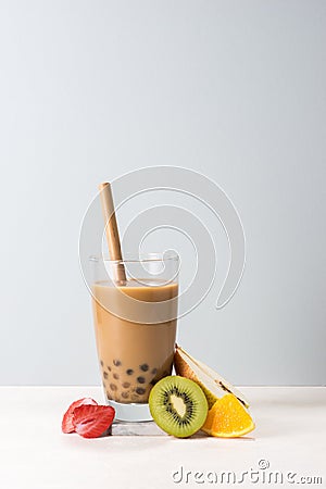 Boba/ buble tea glass with kiwi, strawberry, orange slices on blue background Stock Photo