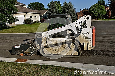 Bobcat excavator cleaning a street Editorial Stock Photo