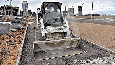 Bobcat skid-steer loader for loading and unloading works on city streets. ompact construction equipment for work in limited Stock Photo