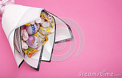 BOBRUISK, BELARUS 20.11.21: Children`s bouquet of candies and sweets on a pink background. Holiday gift for a child. Copy space Editorial Stock Photo