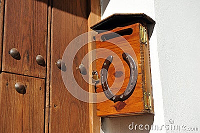 Buzon de cartas de madera con candado y herradura en la fachada de una vivienda unifamiliar Stock Photo