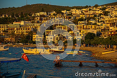 BODRUM, TURKEY: Cityscape on the boardwalk with boat view in the evening at sunset in Bodrum. Editorial Stock Photo