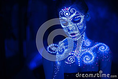 Body art on the body and hand of a girl glowing in the ultraviolet light Stock Photo