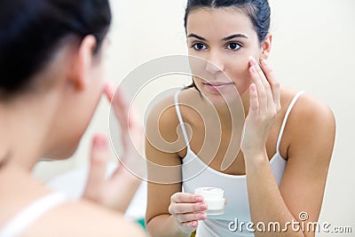 Body care. Woman applying cream on face Stock Photo