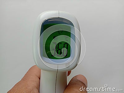 Body infared thermometer in hand, checking at 36 degree on white background closeup. Stock Photo