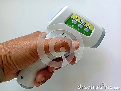 Body infared thermometer in hand on white background closeup. Stock Photo