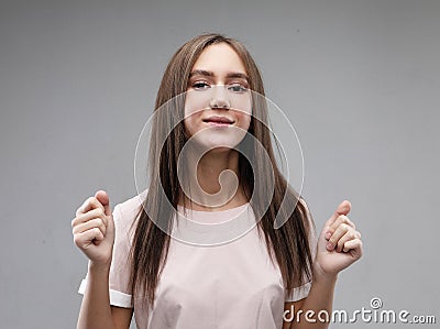 Body language. Superstitious teenager girl hoping her wishes will come true, having excited happy look Stock Photo