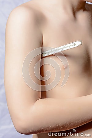 The body of a small boy, who holds a thermometer at hand and measures the body Stock Photo