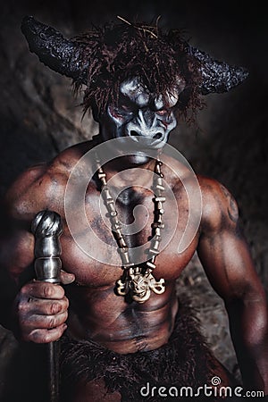 The bodyart man angry minotaur with axe in cave Stock Photo