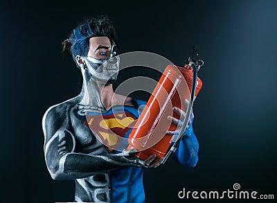 Bodyart of a super hero holding a fire extinguisher in the hands Editorial Stock Photo