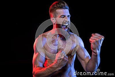 Bodybuilder gesturing and yelling isolated on black with dramatic lighting Stock Photo