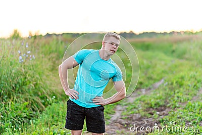 Bodybuilder gymnastics in the park in a T-shirt. Summer lifestyle is outdoor recreation, motivation is strong. Muscular Stock Photo