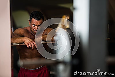 Bodybuilder resting after doing heavy weight exercise Stock Photo